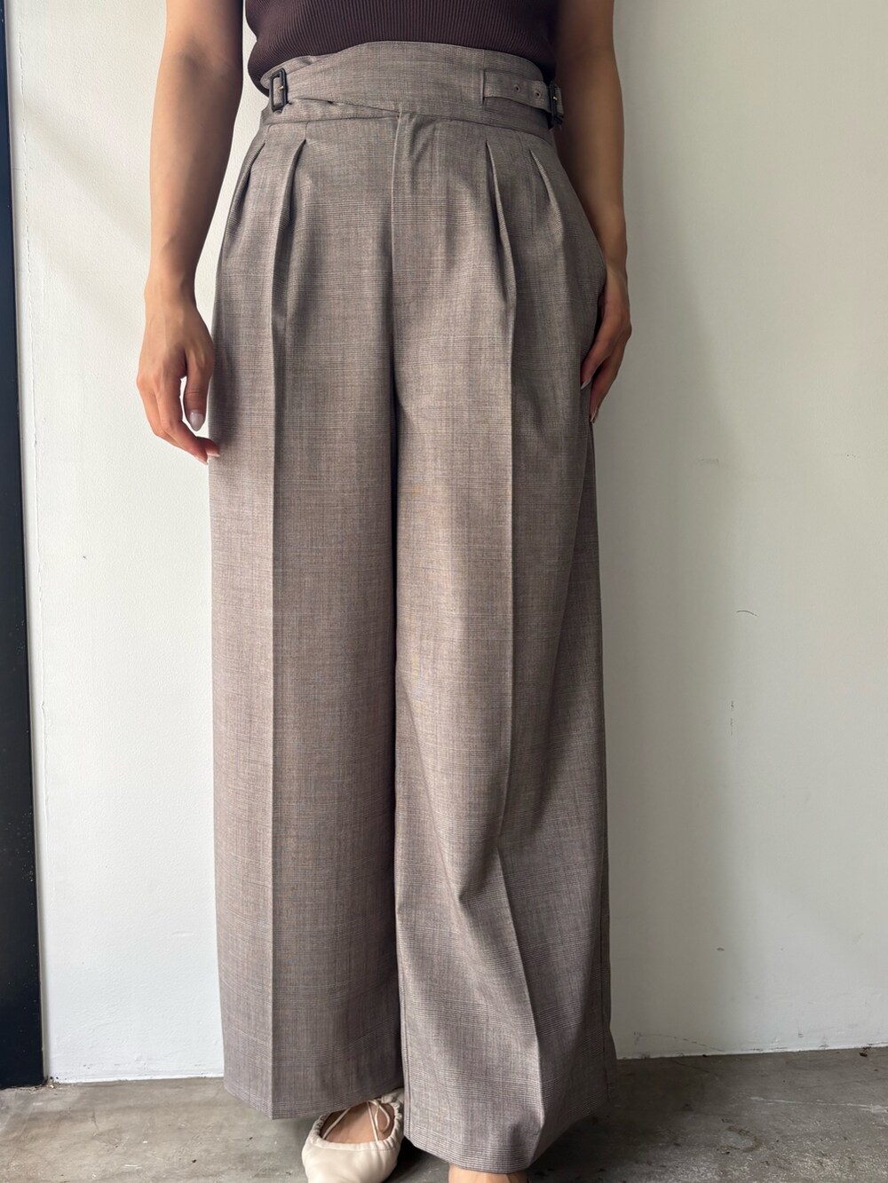 ブラウン系のニット/セーター、ベージュ系のその他パンツ、ホワイト系のサンダルを着用したレディースの春コーディネートの5枚目の写真