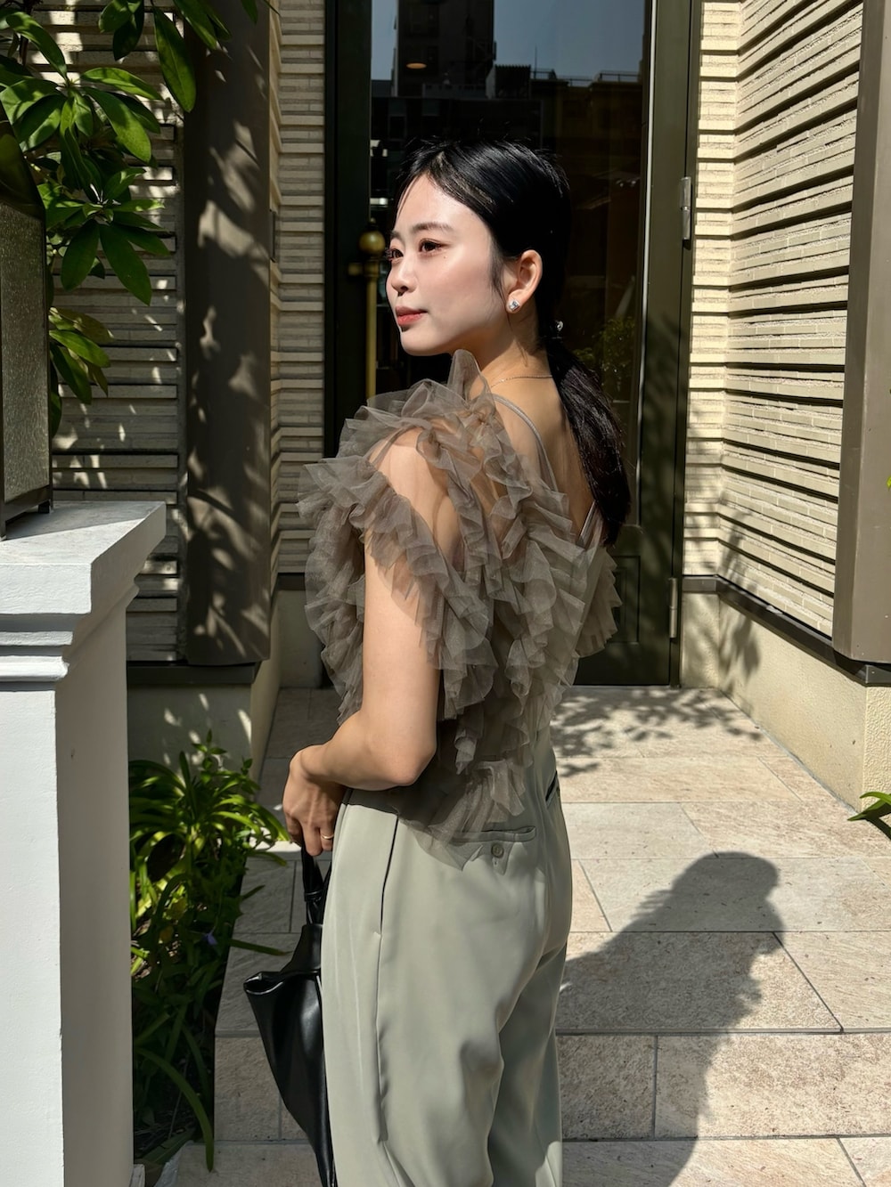 グリーン系のパンツドレスを着用したレディースの春コーディネートの2枚目の写真