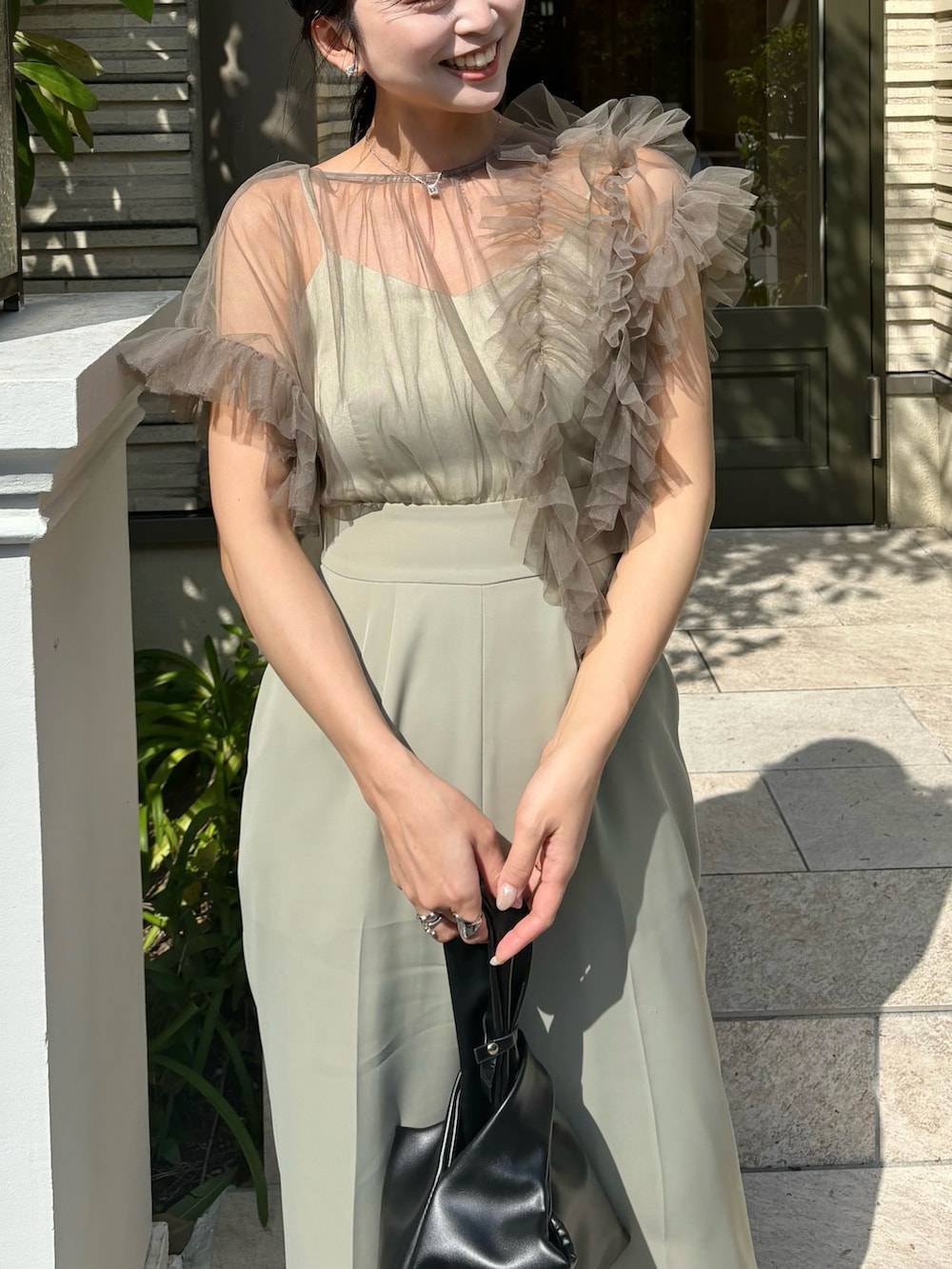 グリーン系のパンツドレスを着用したレディースの春コーディネートの3枚目の写真