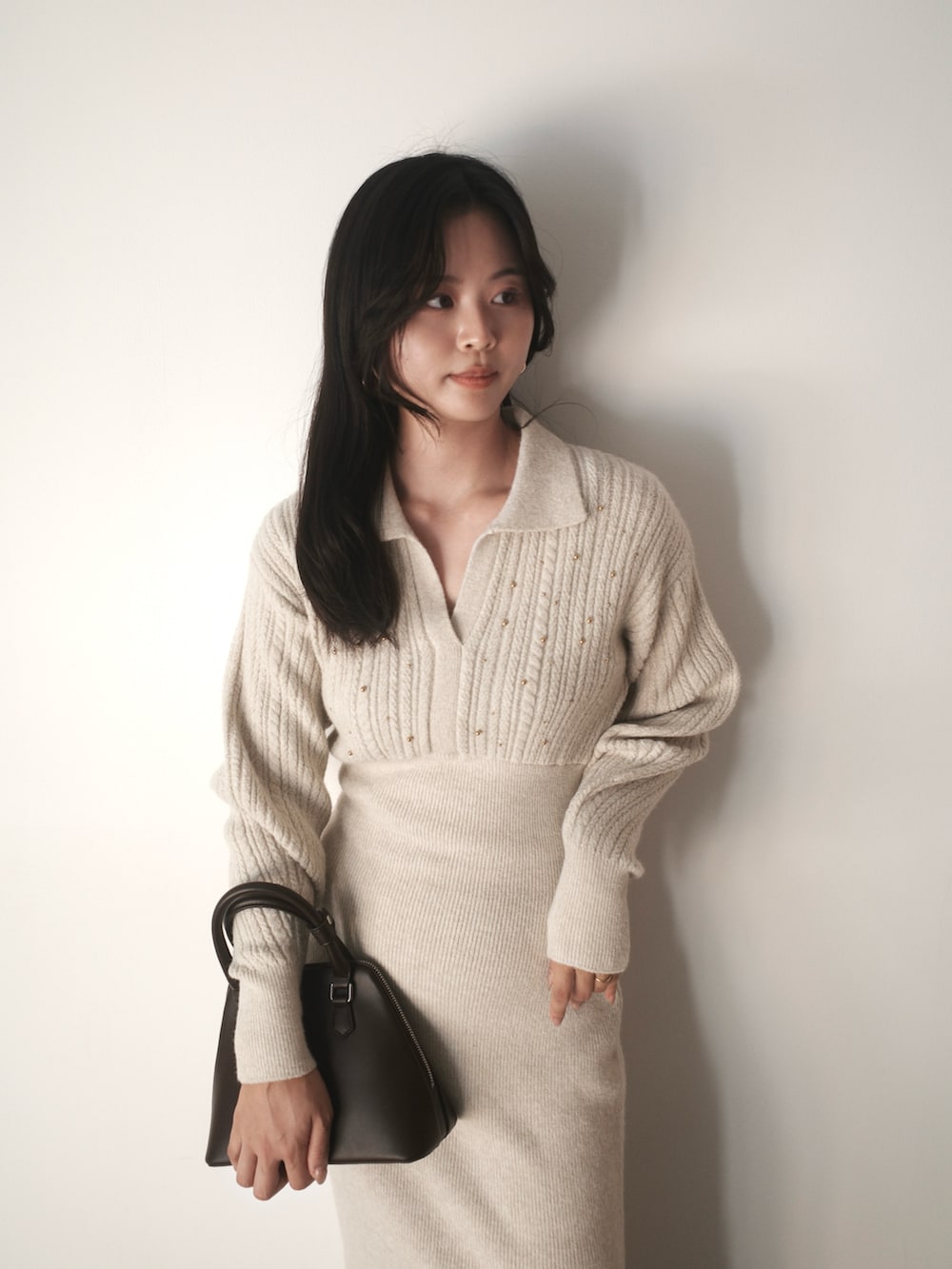 ベージュ系のワンピース、ブラウン系のボストンバッグ、ブラウン系のパンプスを着用したレディースの秋コーディネートの4枚目の写真