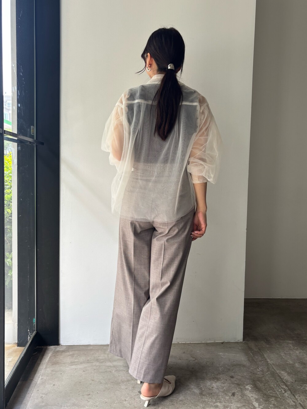 ブラウン系のニット/セーター、ベージュ系のその他パンツ、ホワイト系のサンダルを着用したレディースの春コーディネートの3枚目の写真