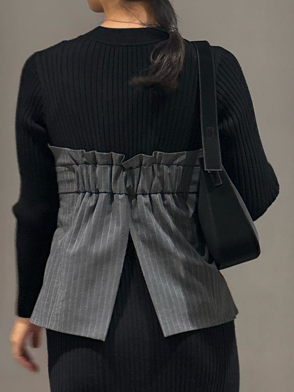 ブラック系のワンピース、ブラック系のハンドバッグ、ブラック系のブーツを着用したレディースの冬コーディネートの8枚目の写真