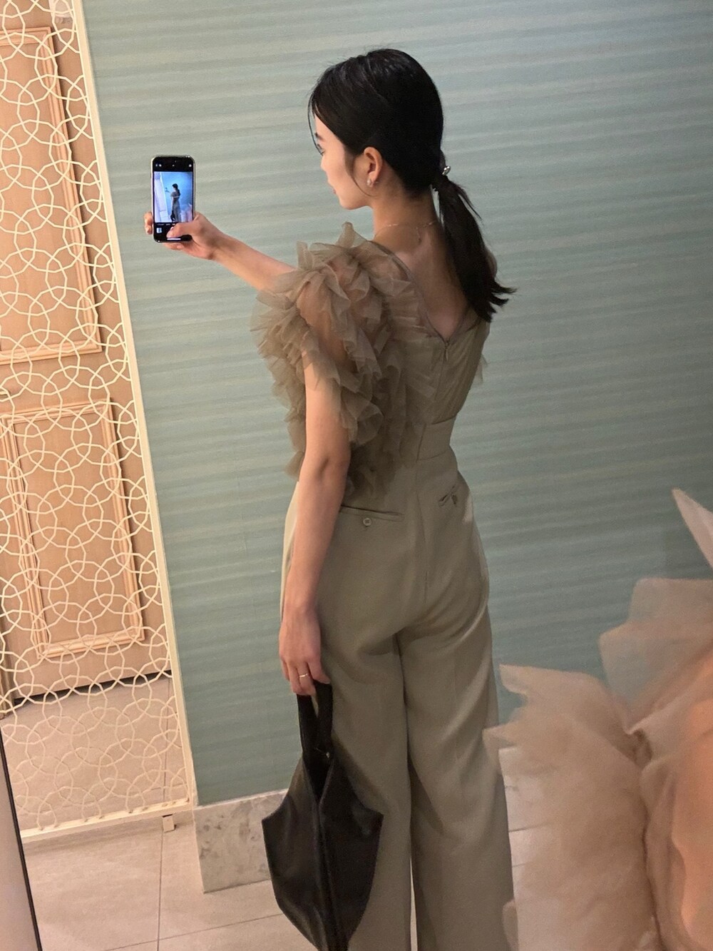 グリーン系のパンツドレスを着用したレディースの春コーディネートの4枚目の写真