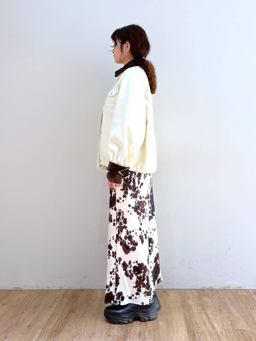 ブラック系のブーツ、その他のスカート、ブラウン系のTシャツ/カットソーを着用したレディースの秋コーディネートの2枚目の写真