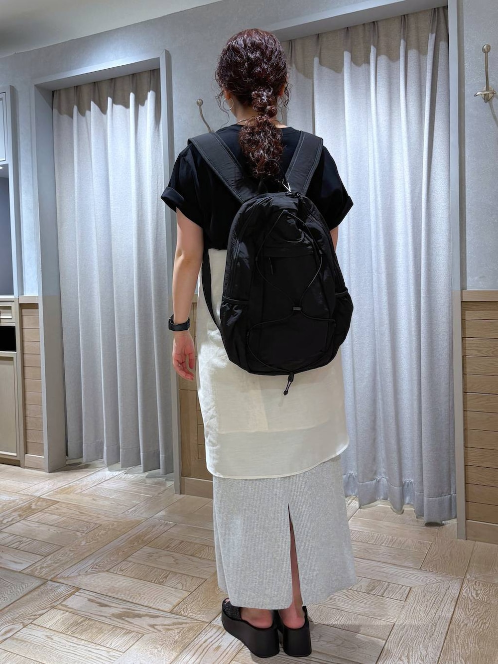 グレー系のスカート、ホワイト系のシャツ/ブラウス、ブラック系のサンダルを着用したレディースの夏コーディネートの3枚目の写真