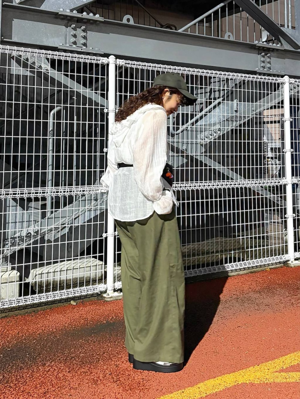 シルバー系のタンクトップ、ホワイト系のシャツ/ブラウス、ブラック系のボディバッグ/ウエストポーチを着用したレディースの春コーディネートの2枚目の写真