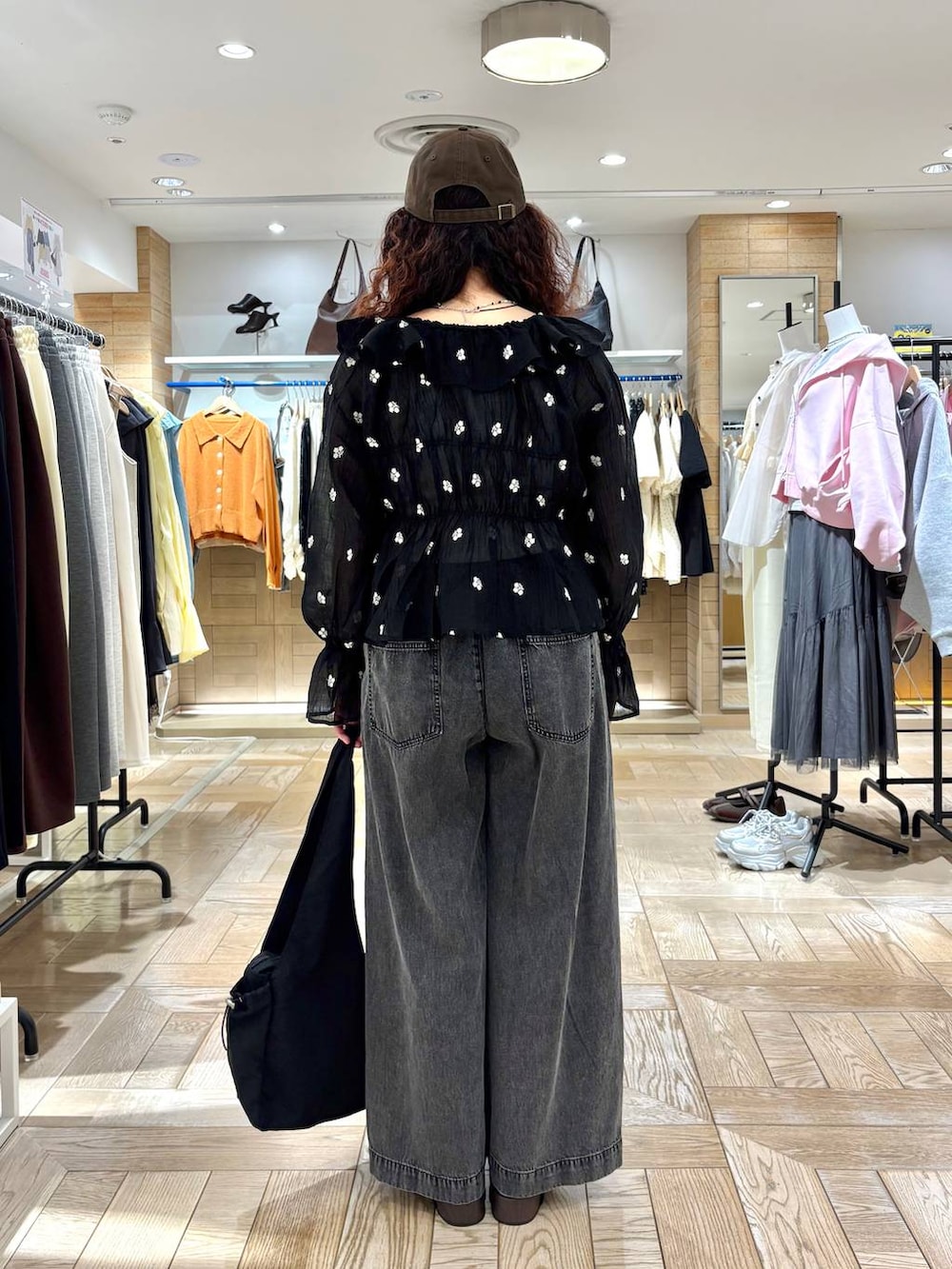 シルバー系のタンクトップ、ブラック系のデニムパンツ、ブラック系のサンダルを着用したレディースの春コーディネートの3枚目の写真