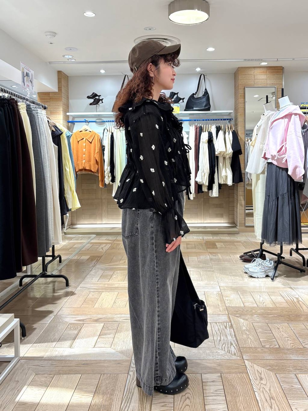 シルバー系のタンクトップ、ブラック系のデニムパンツ、ブラック系のサンダルを着用したレディースの春コーディネートの2枚目の写真