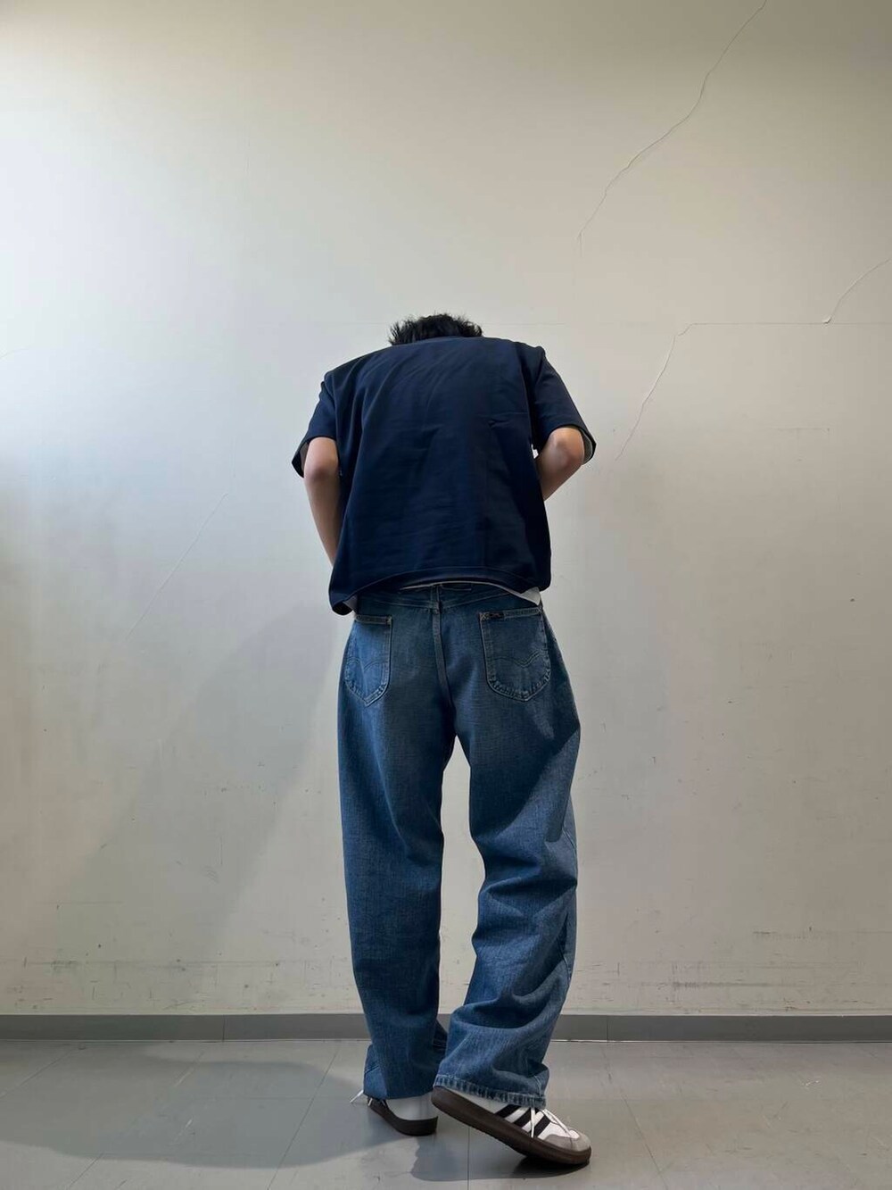 ブルー系のデニムパンツ、ホワイト系のTシャツ/カットソー、ブルー系のキャップを着用したメンズの春コーディネートの3枚目の写真