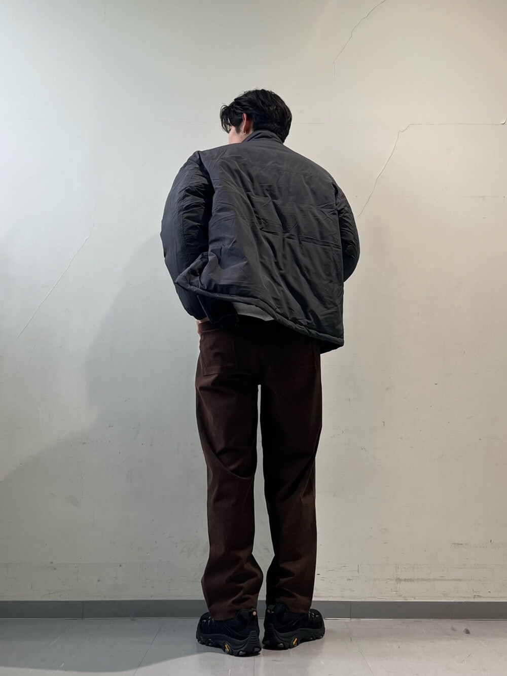 グレー系のその他アウター、ブラウン系のその他パンツ、ブラック系のスニーカーを着用したメンズの冬コーディネートの3枚目の写真