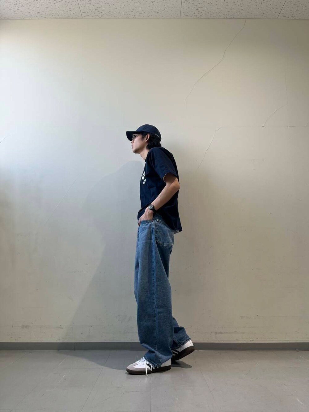 ブルー系のデニムパンツ、ホワイト系のTシャツ/カットソー、ブルー系のキャップを着用したメンズの春コーディネートの2枚目の写真