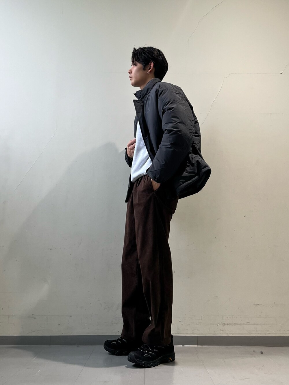 グレー系のその他アウター、ブラウン系のその他パンツ、ブラック系のスニーカーを着用したメンズの冬コーディネートの2枚目の写真