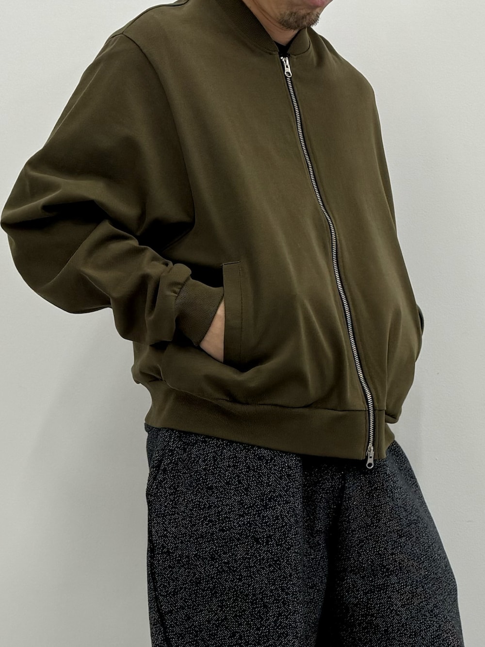 グリーン系のスウェット、グレー系のスウェットパンツを着用したメンズの冬コーディネートの2枚目の写真