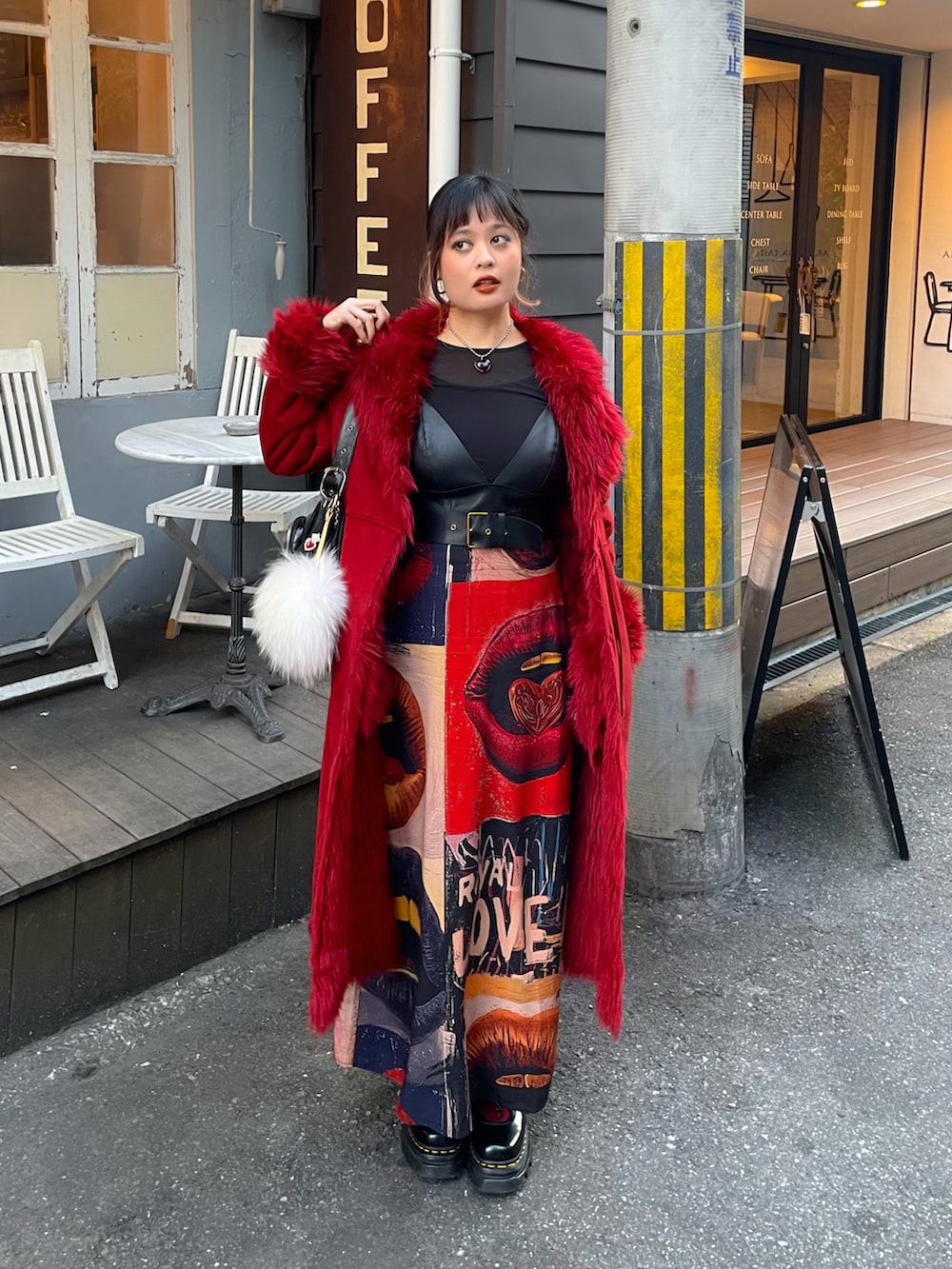 ブラック系のワンピース、レッド系のその他アウター、ブラック系のブーツを着用したレディースの冬コーディネートの2枚目の写真