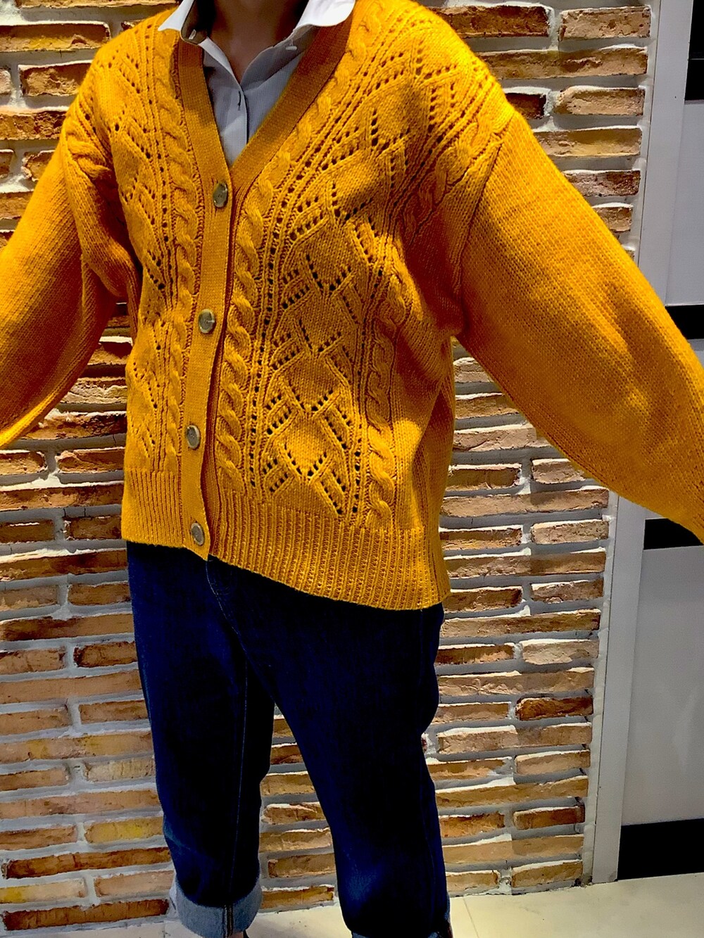 イエロー系のカーディガン/ボレロを着用したレディースの秋コーディネートの2枚目の写真