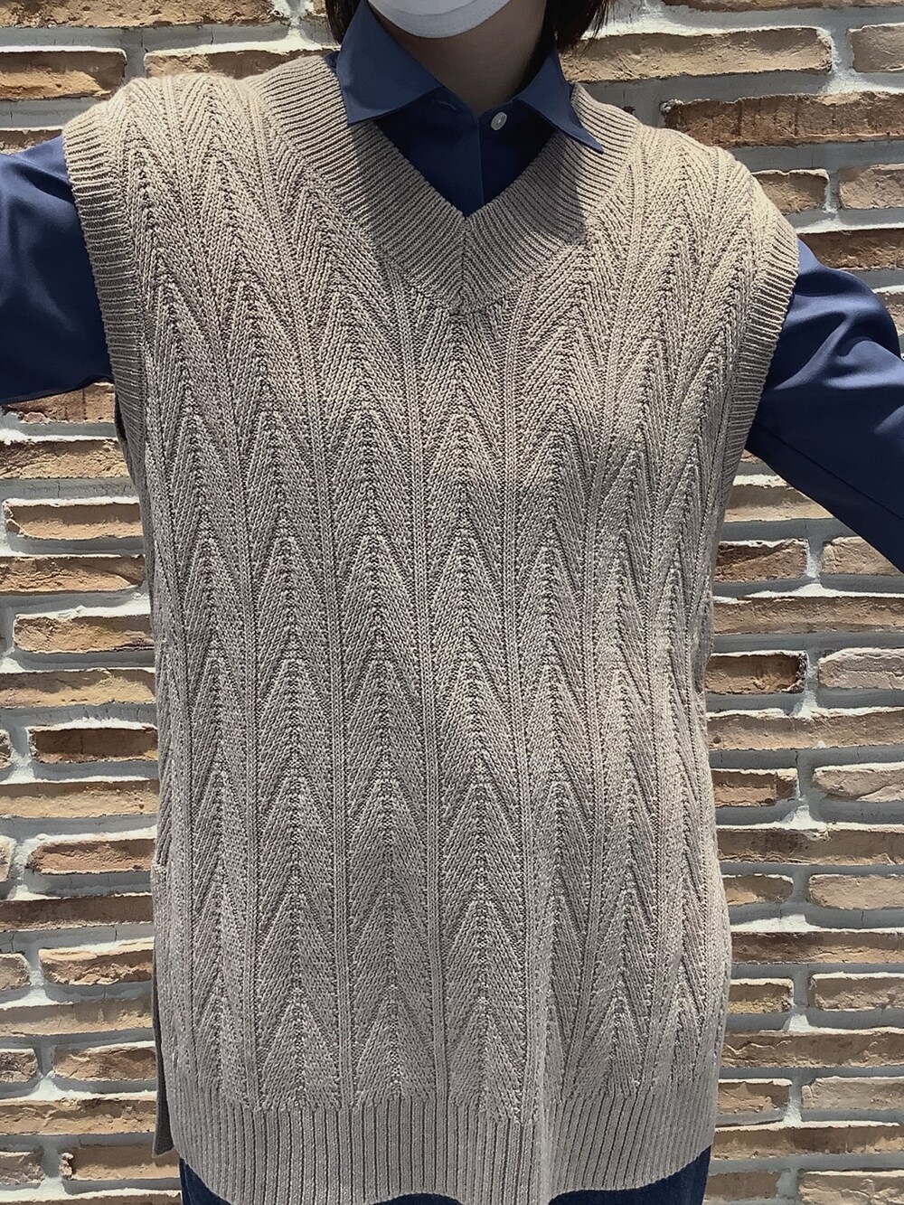 ベージュ系のベスト、ブルー系のビジネスシャツを着用したレディースの秋コーディネートの2枚目の写真