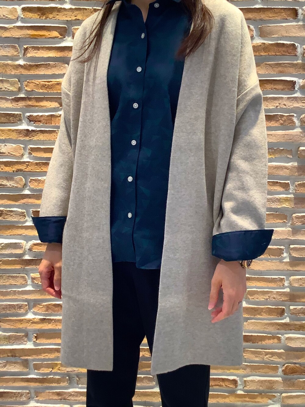 ブルー系のビジネスシャツ、ベージュ系のカーディガン/ボレロを着用したレディースの秋コーディネートの2枚目の写真