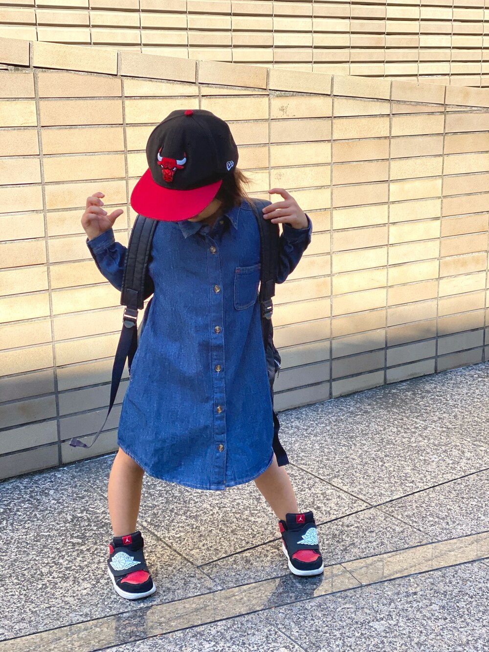 ブルー系のワンピース、ベージュ系のトップス、ブラック系のスニーカーを着用したキッズの秋コーディネートの2枚目の写真