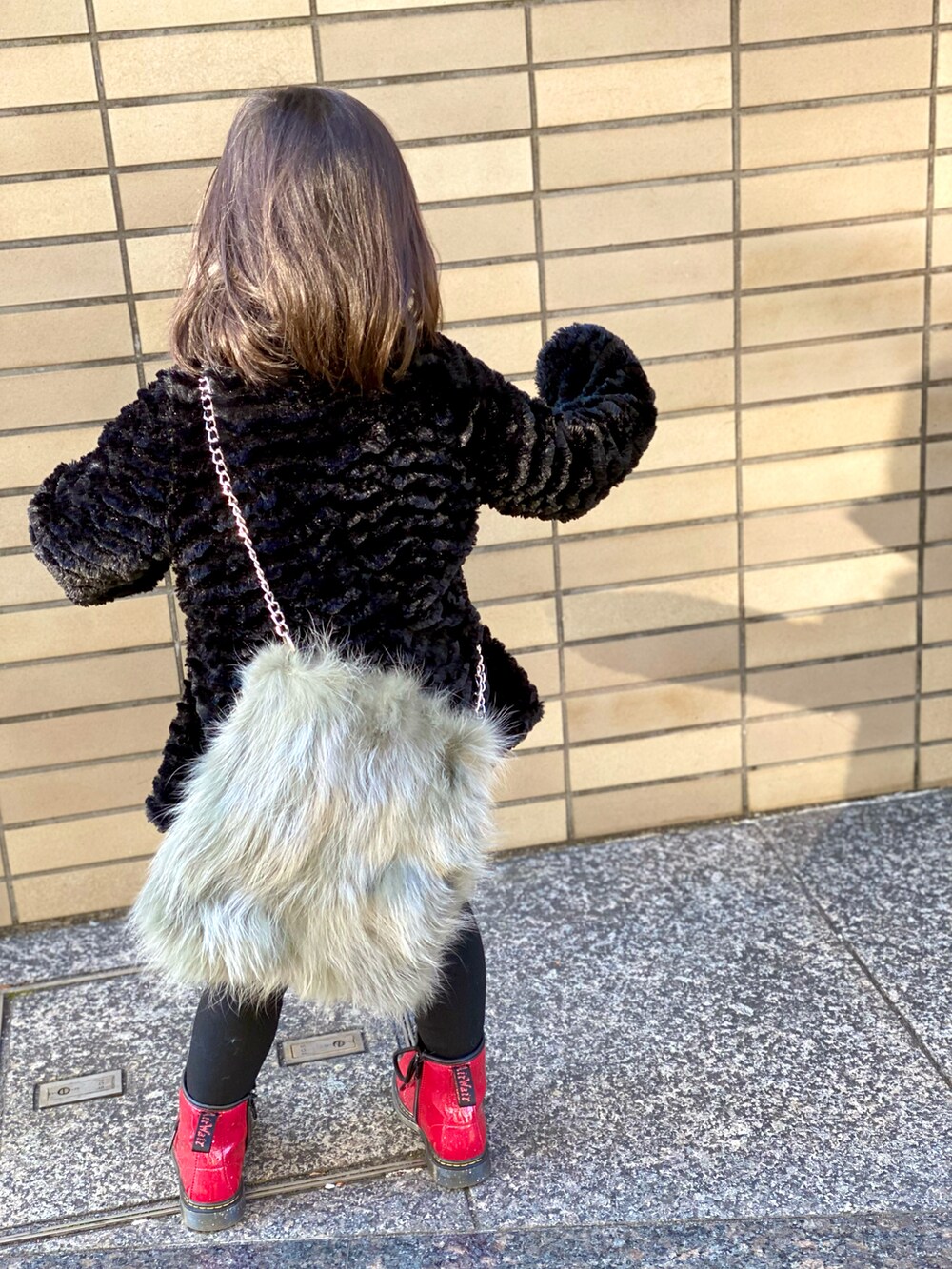「キッズファッション、patagonia、Dr.Martens、ブーツ、コート、黒コーデ、赤、シンプルコーデ、ショルダーバッグ、カジュアルコーデ、ファーバッグ、ワントーンコーデ」｜「patagoniaのアイテム（ジャケット/アウター、ブラック系）」を使った、Rin&Rayさん（キッズ・100cm）の冬コーディネートの4枚目の写真
