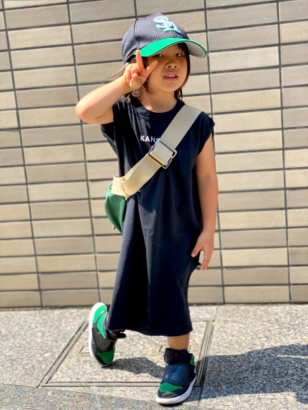 ブラック系のワンピース、グリーン系のボディバッグ/ウエストポーチ、グリーン系のスニーカーを着用したキッズの秋コーディネートの5枚目の写真