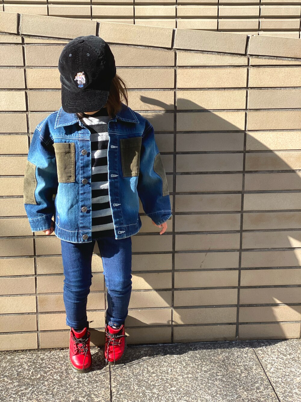ブルー系のデニムパンツ、レッド系のブーツ、ブルー系のデニムジャケットを着用したキッズの冬コーディネートの2枚目の写真