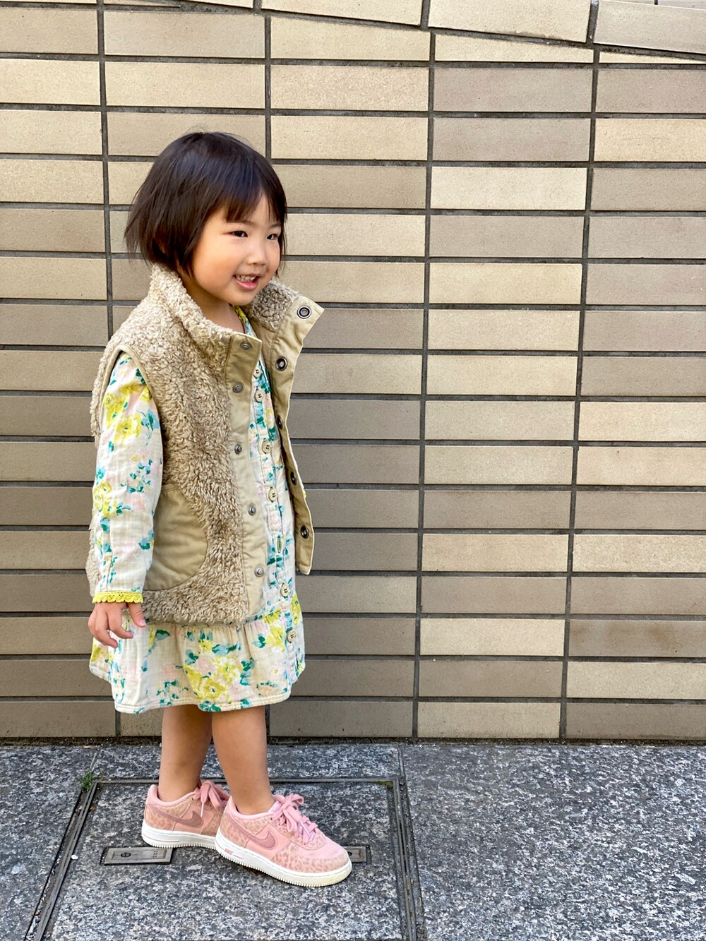 「春コーデ、キッズコーデ、花柄、花柄ワンピース、黄色、ピンク、ベスト、裸足にスニーカー、ジョジョ立ち」｜「DIESELのアイテム（ベスト、ベージュ系）」を使った、Rin&Rayさん（キッズ・100cm）の春コーディネートの3枚目の写真