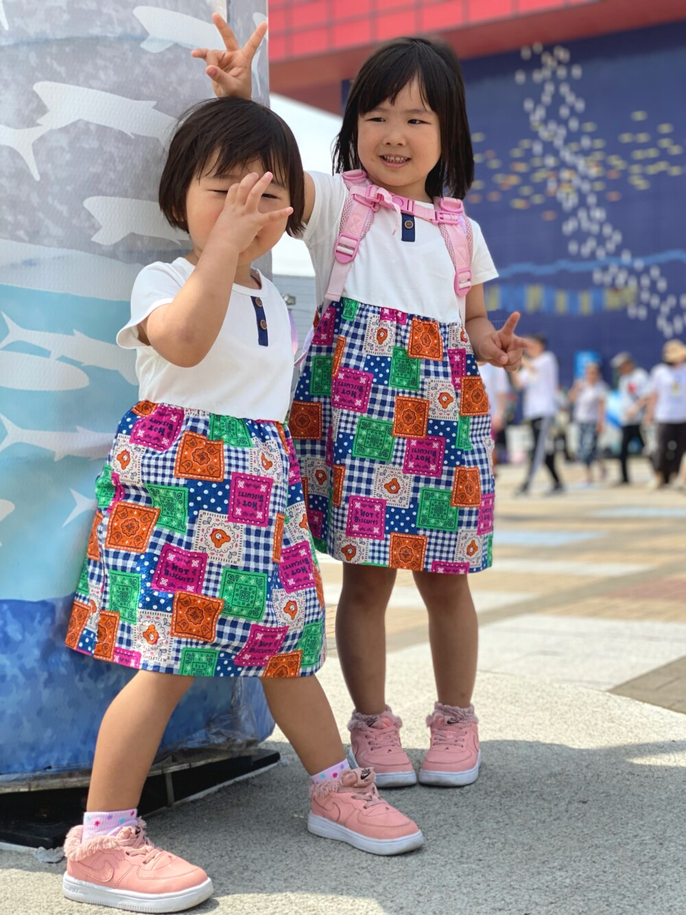 ピンク系のスニーカー、ホワイト系のワンピースを着用したキッズの春コーディネートの2枚目の写真