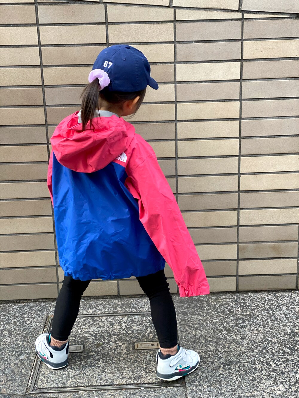 ブラック系のその他パンツ、ピンク系のジャケット/アウター、ホワイト系のスニーカーを着用したキッズの冬コーディネートの3枚目の写真