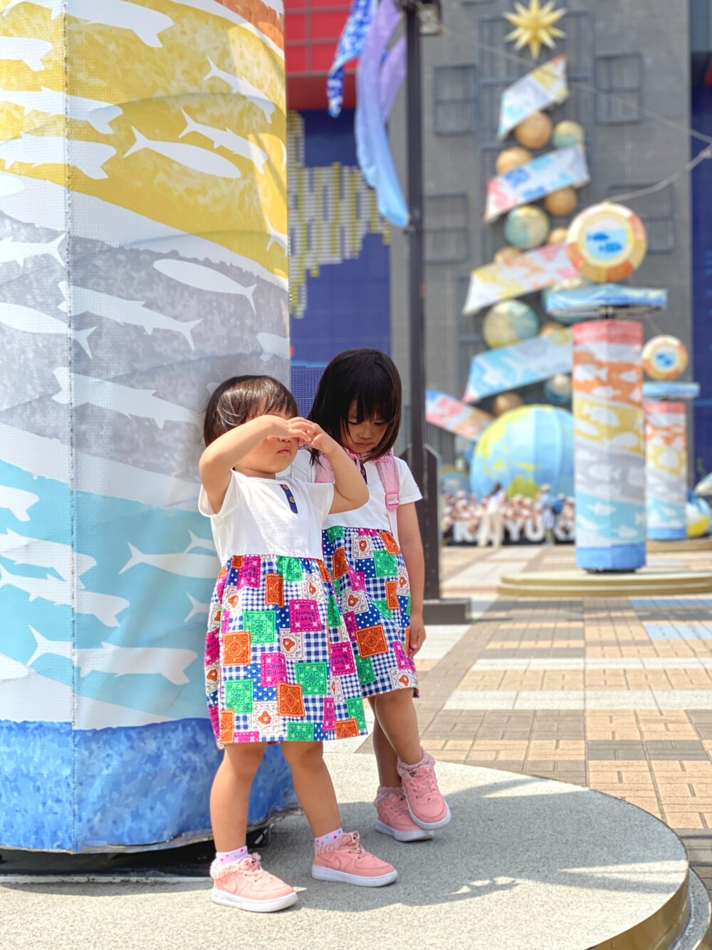 ピンク系のスニーカー、ホワイト系のワンピースを着用したキッズの春コーディネートの3枚目の写真