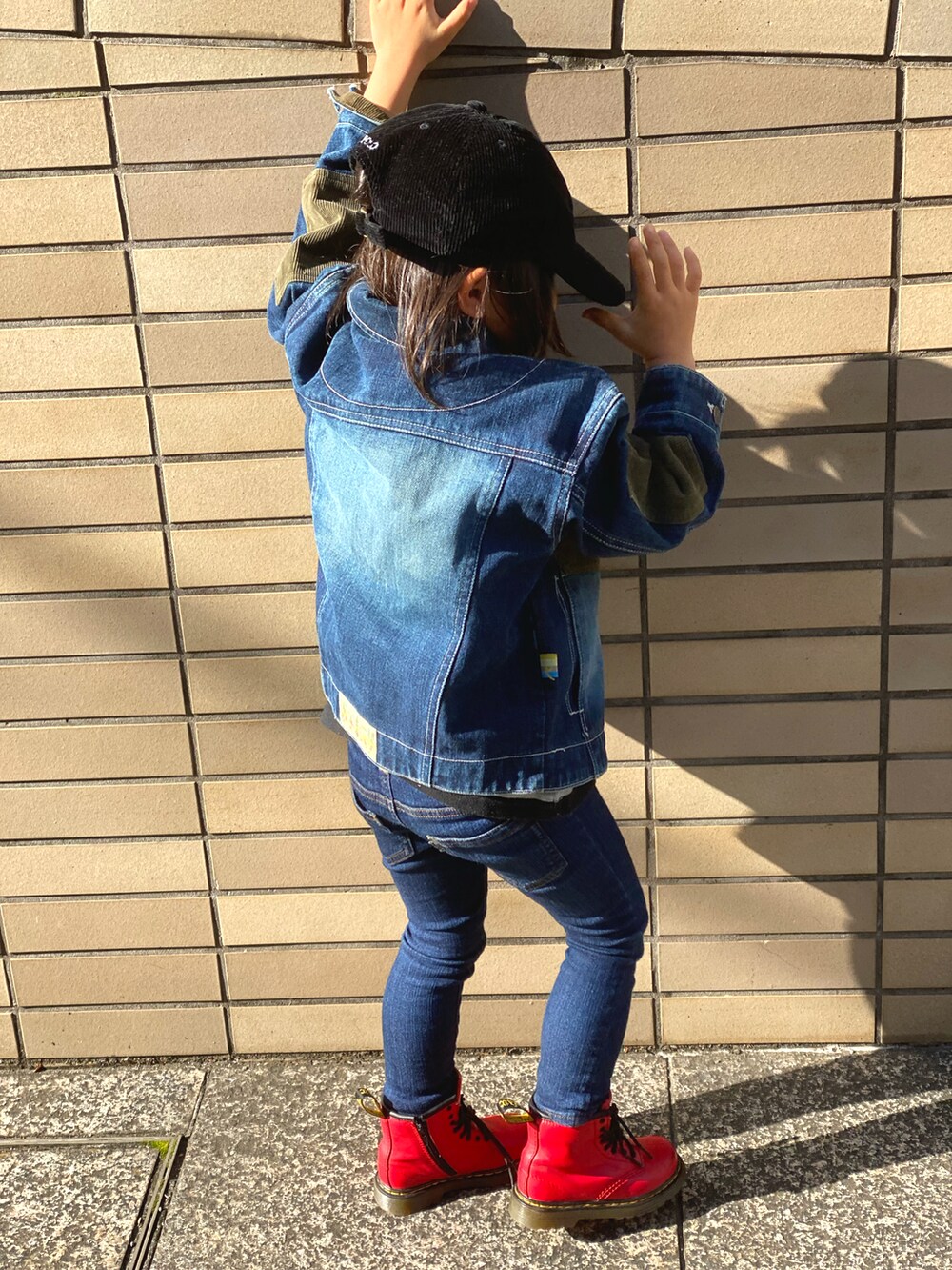 ブルー系のデニムパンツ、レッド系のブーツ、ブルー系のデニムジャケットを着用したキッズの冬コーディネートの4枚目の写真