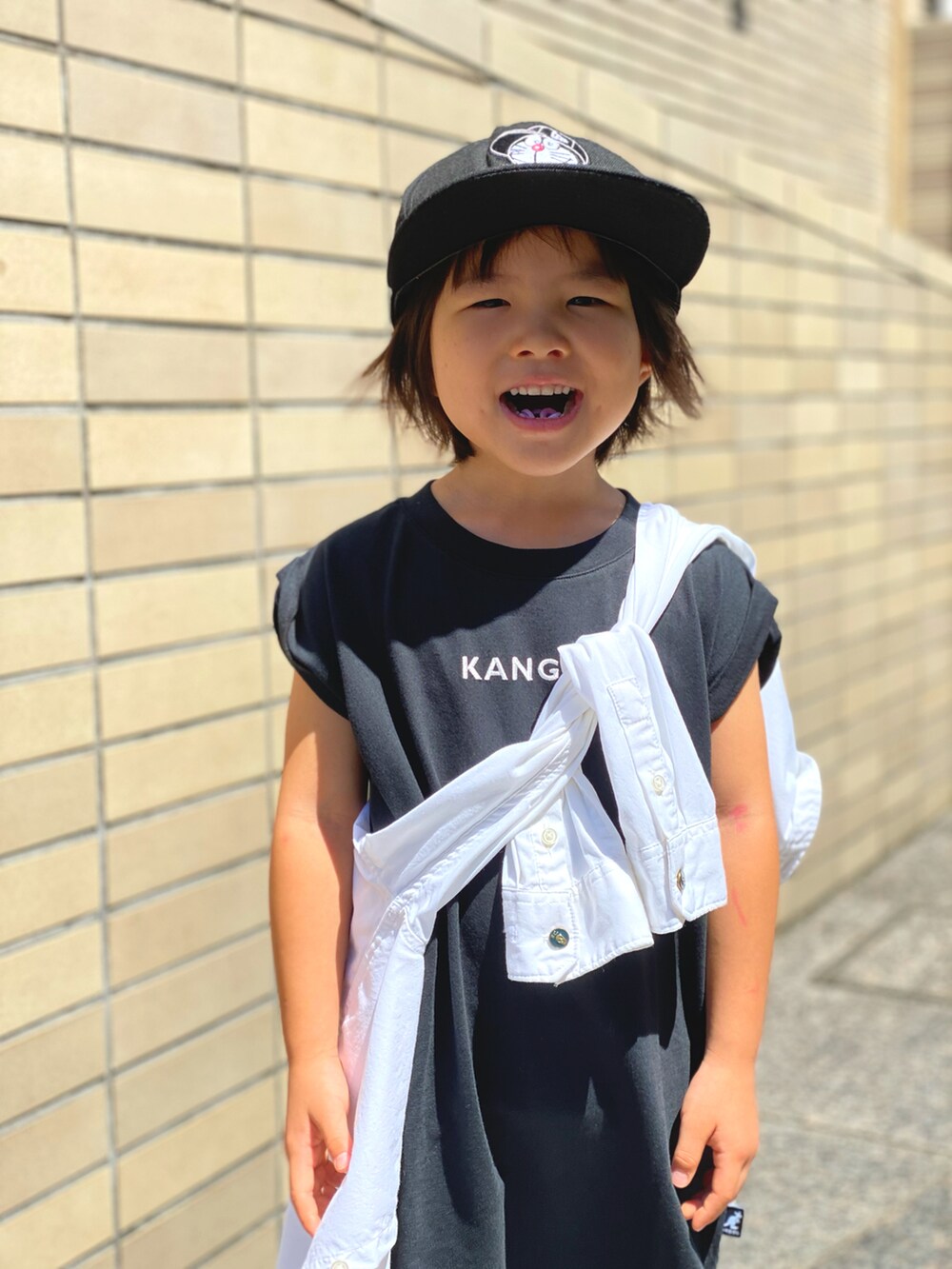 「たすき掛け、シャツスタイル、Tシャツ、Tシャツワンピ、バンズ、スニーカー、ブラック×ホワイト、ニューエラ、カンゴール、夏コーデ、scotch&soda、カジュアルコーデ、キャップ、ロゴT、モノトーン」｜「NEW ERAのニューエラ KIDS ドラえもん シッティング（キャップ、ブラック系）」を使った、Rin&Rayさん（キッズ・100cm）の夏コーディネートの5枚目の写真