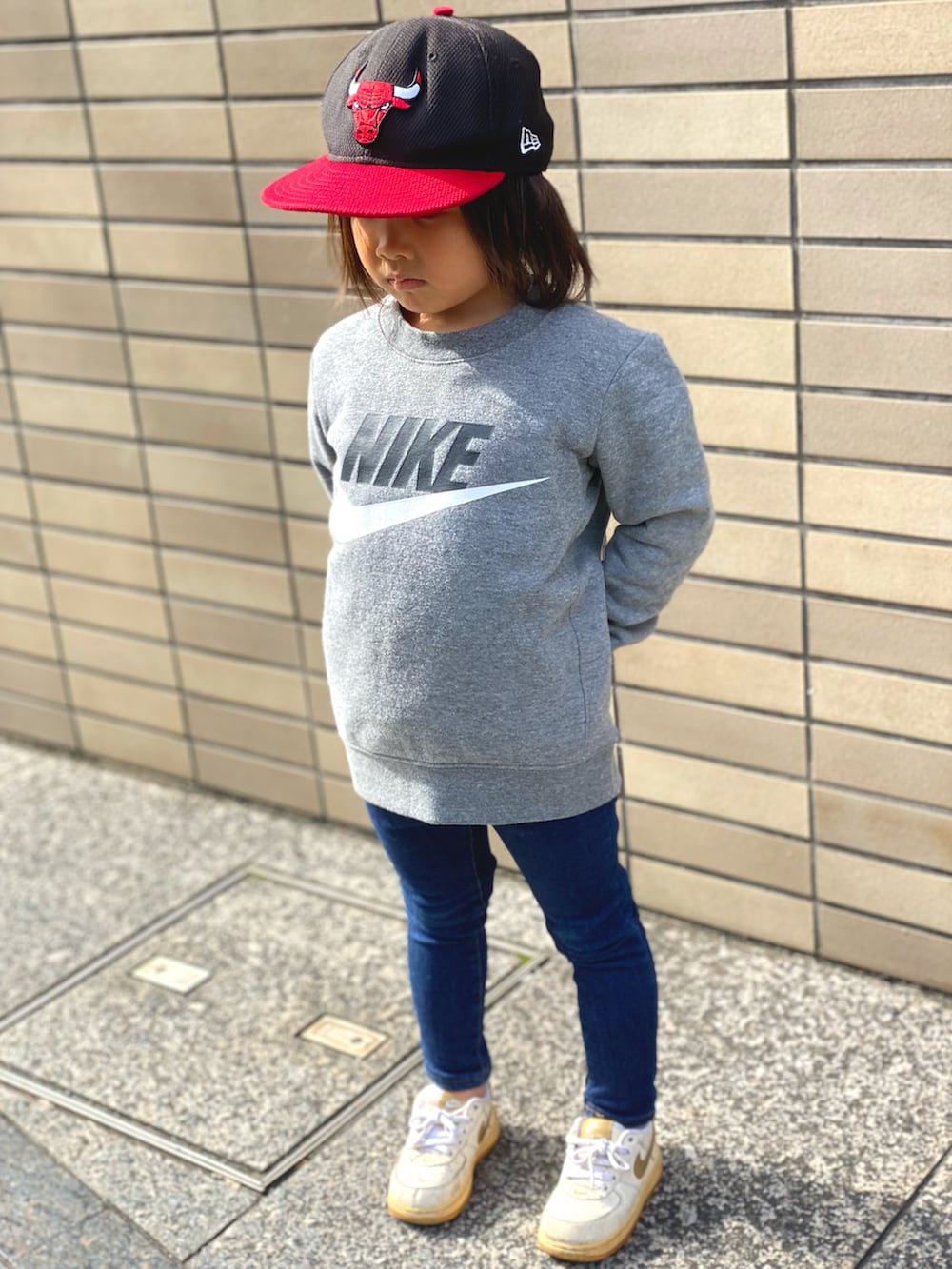 グレー系のスウェット、ブルー系のデニムパンツ、ホワイト系のスニーカーを着用したキッズの秋コーディネートの4枚目の写真