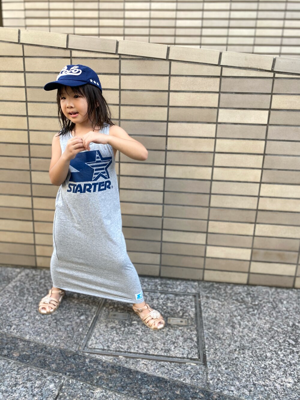グレー系のワンピース、ブルー系のキャップを着用したキッズの夏コーディネートの3枚目の写真