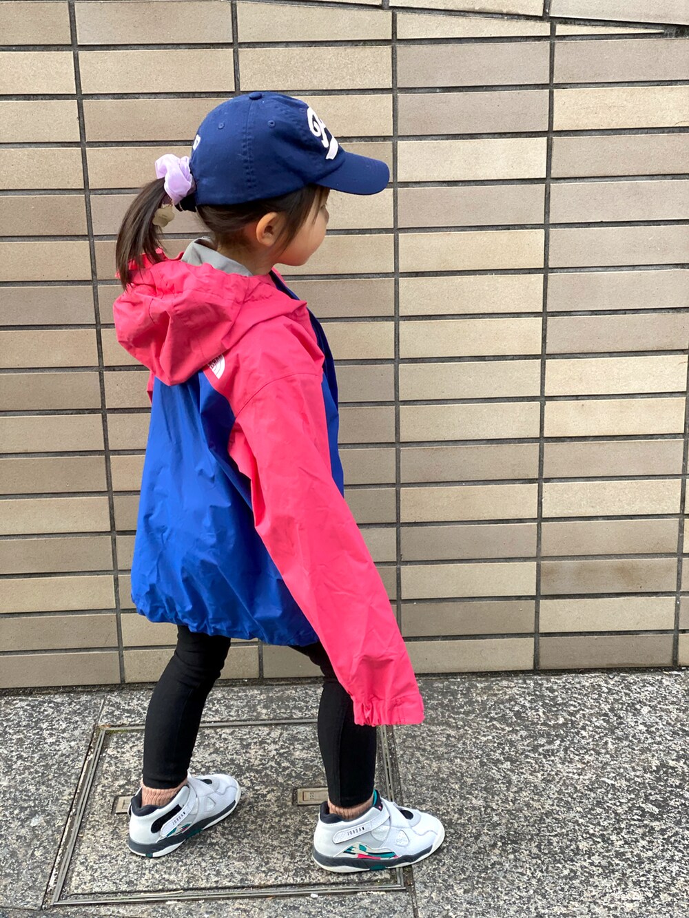 ブラック系のその他パンツ、ピンク系のジャケット/アウター、ホワイト系のスニーカーを着用したキッズの冬コーディネートの2枚目の写真