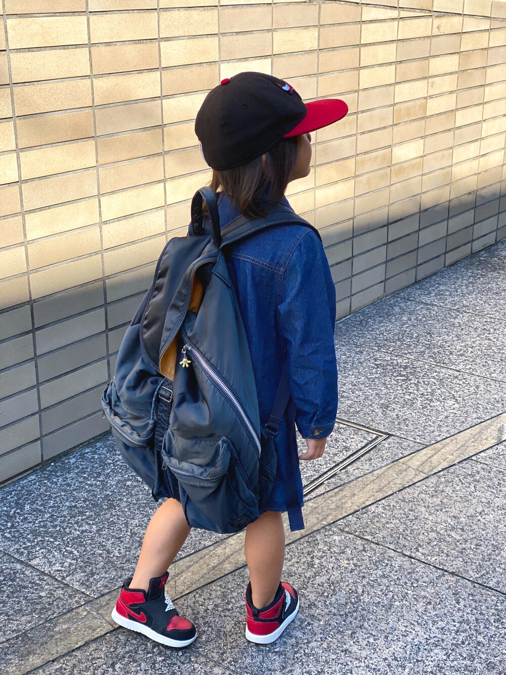 ブルー系のワンピース、ベージュ系のトップス、ブラック系のスニーカーを着用したキッズの秋コーディネートの4枚目の写真