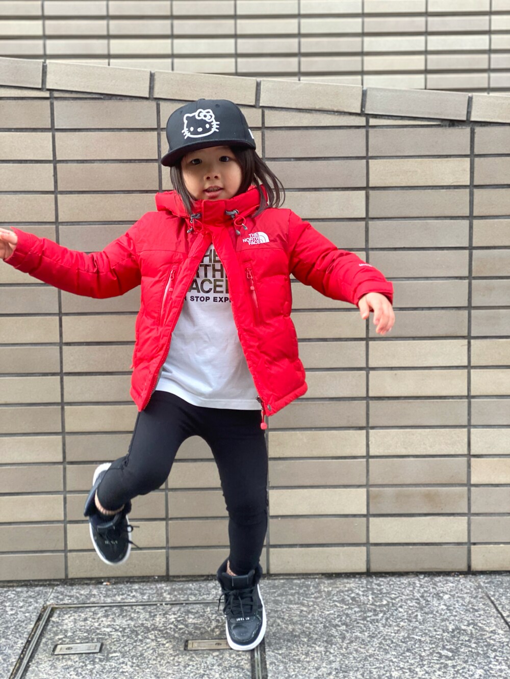 レッド系のダウンジャケット/コート、ホワイト系のTシャツ/カットソー、ブラック系のその他パンツを着用したキッズの冬コーディネートの5枚目の写真