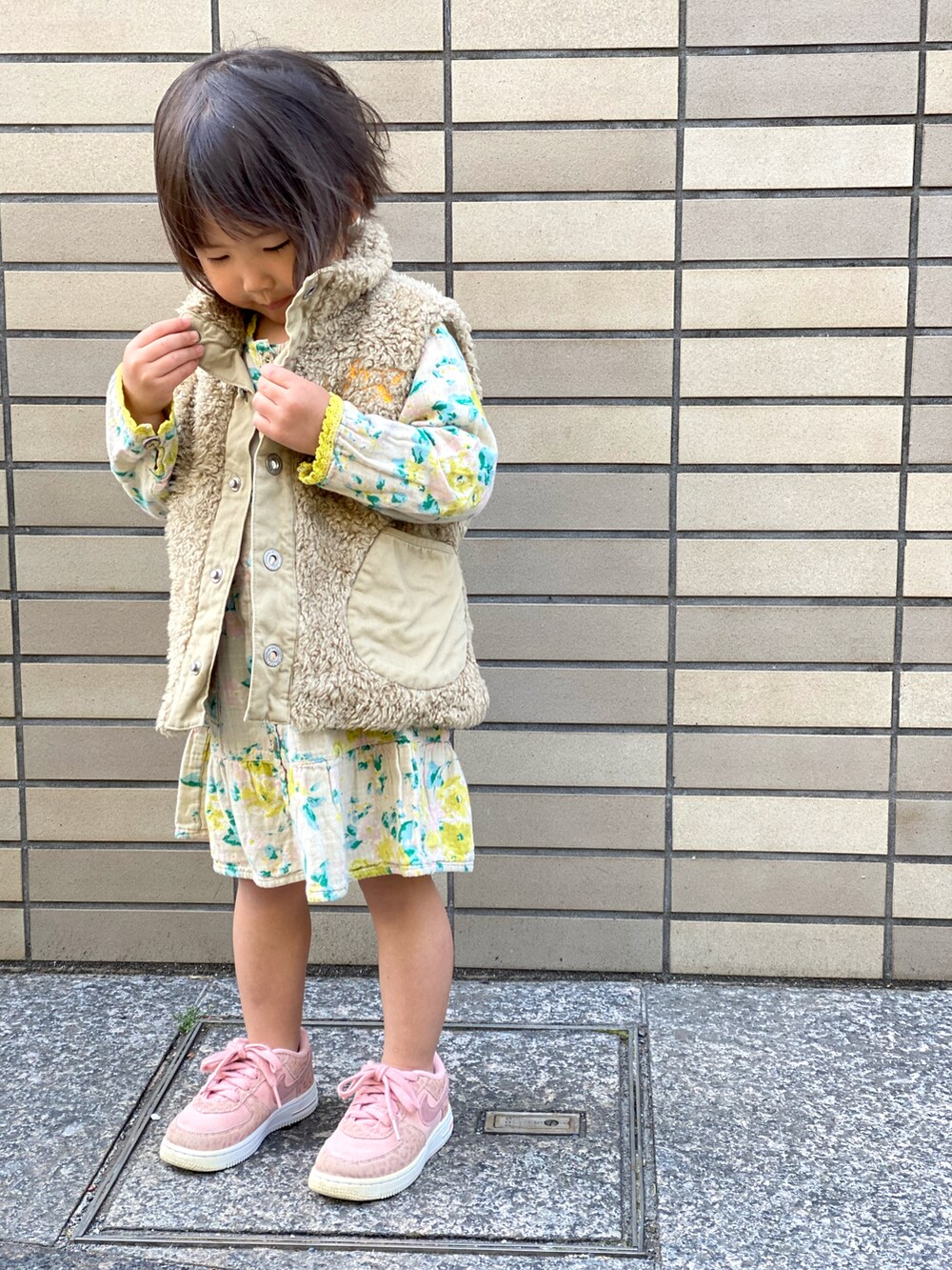 「春コーデ、キッズコーデ、花柄、花柄ワンピース、黄色、ピンク、ベスト、裸足にスニーカー、ジョジョ立ち」｜「DIESELのアイテム（ベスト、ベージュ系）」を使った、Rin&Rayさん（キッズ・100cm）の春コーディネートの2枚目の写真