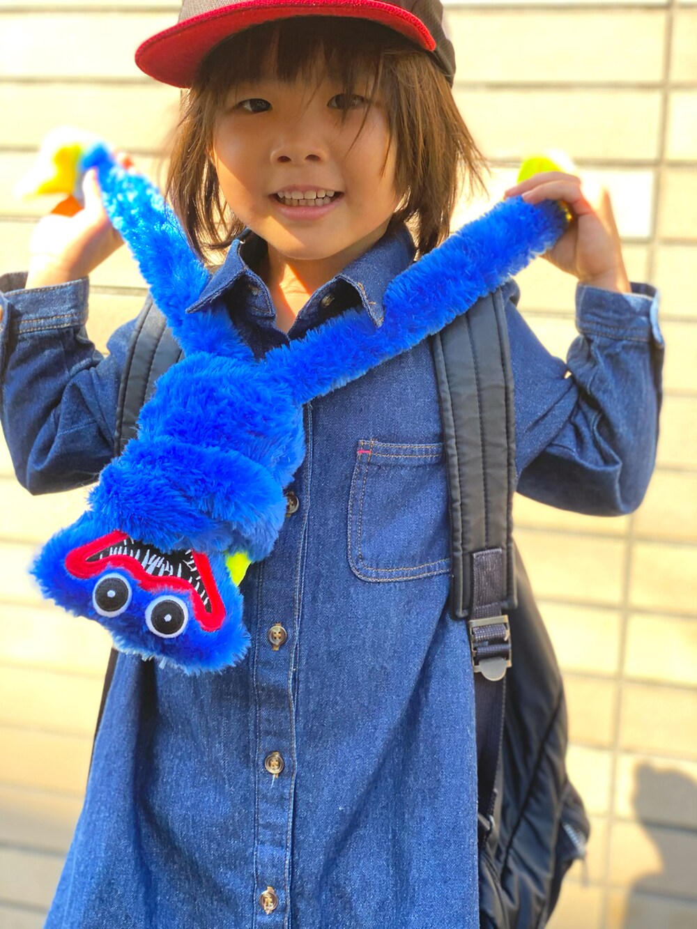 ブルー系のワンピース、ベージュ系のトップス、ブラック系のスニーカーを着用したキッズの秋コーディネートの5枚目の写真