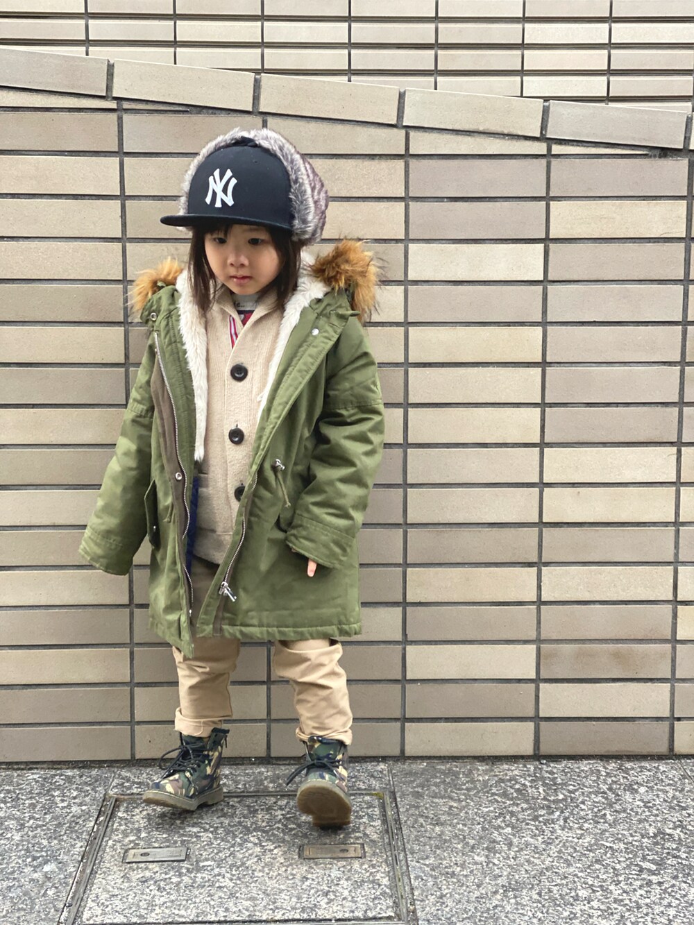 グリーン系のモッズコート、ベージュ系のその他パンツ、その他のブーツを着用したキッズの冬コーディネートの3枚目の写真