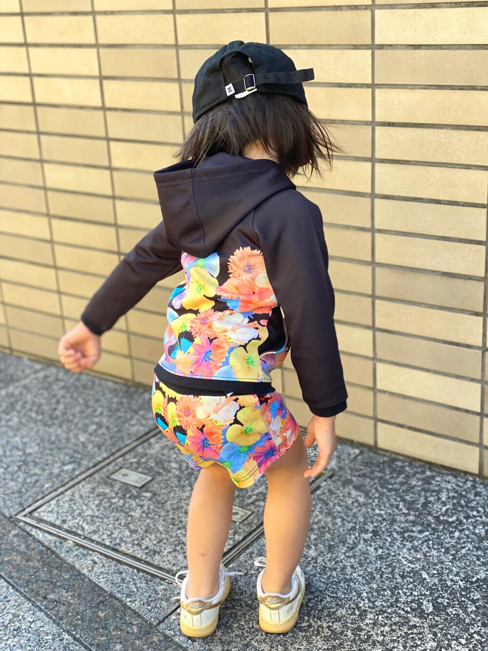 ブラック系のセットアップ、ホワイト系のスニーカー、ブラック系のキャップを着用したキッズの秋コーディネートの3枚目の写真