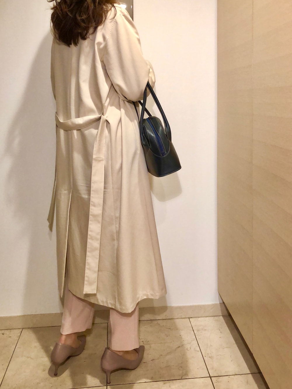 ベージュ系のトレンチコート、ピンク系のパンツ、ベージュ系のパンプスを着用したレディースの春コーディネートの3枚目の写真