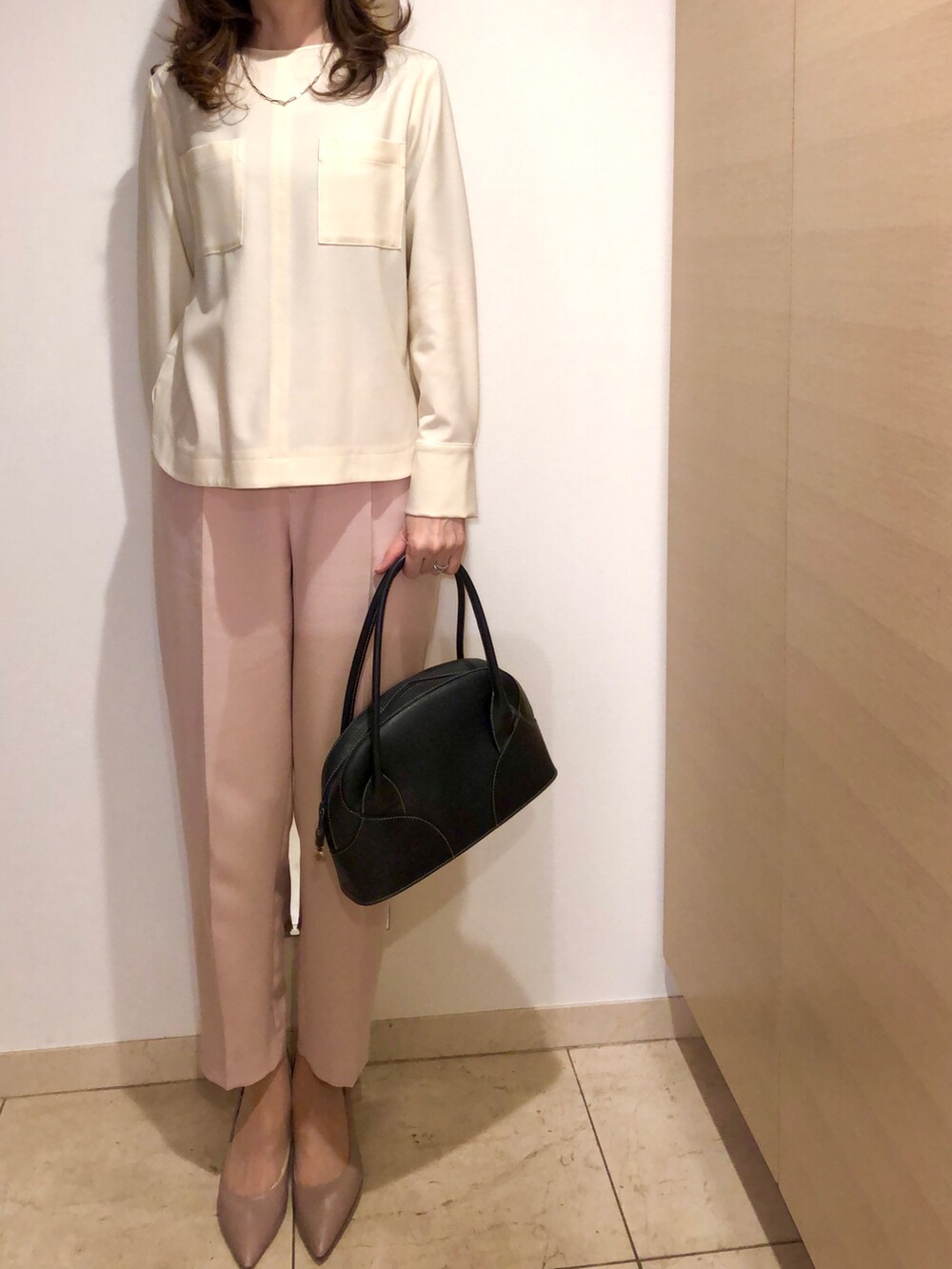 ベージュ系のトレンチコート、ピンク系のパンツ、ベージュ系のパンプスを着用したレディースの春コーディネートの2枚目の写真