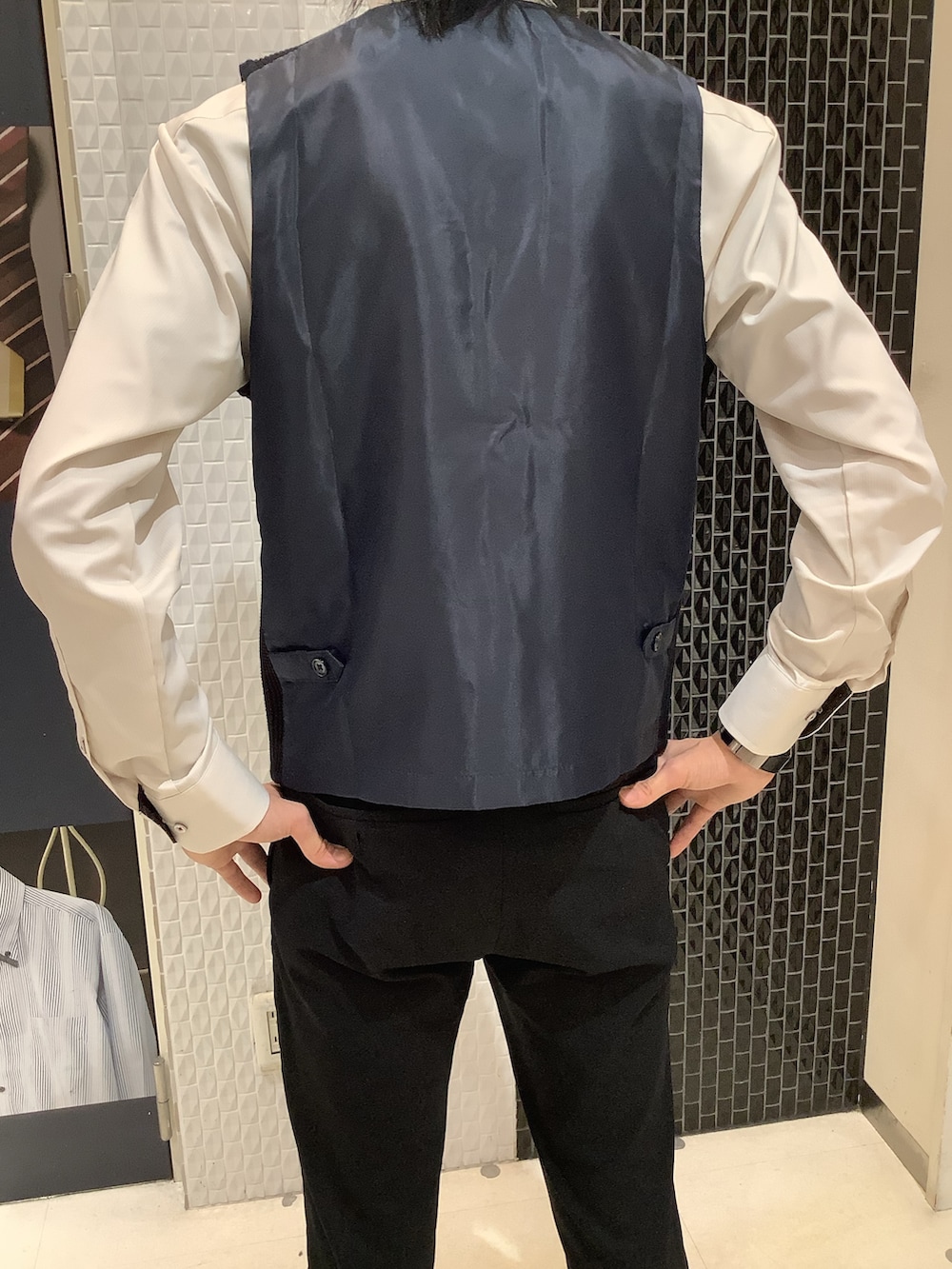 ブルー系のベスト、ベージュ系のビジネスシャツを着用したメンズの秋コーディネートの3枚目の写真