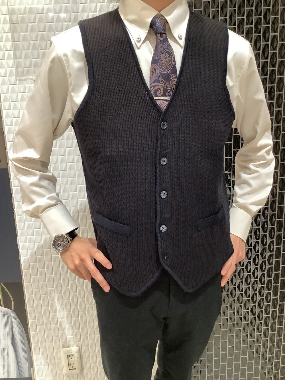 ブルー系のベスト、ベージュ系のビジネスシャツを着用したメンズの秋コーディネートの2枚目の写真