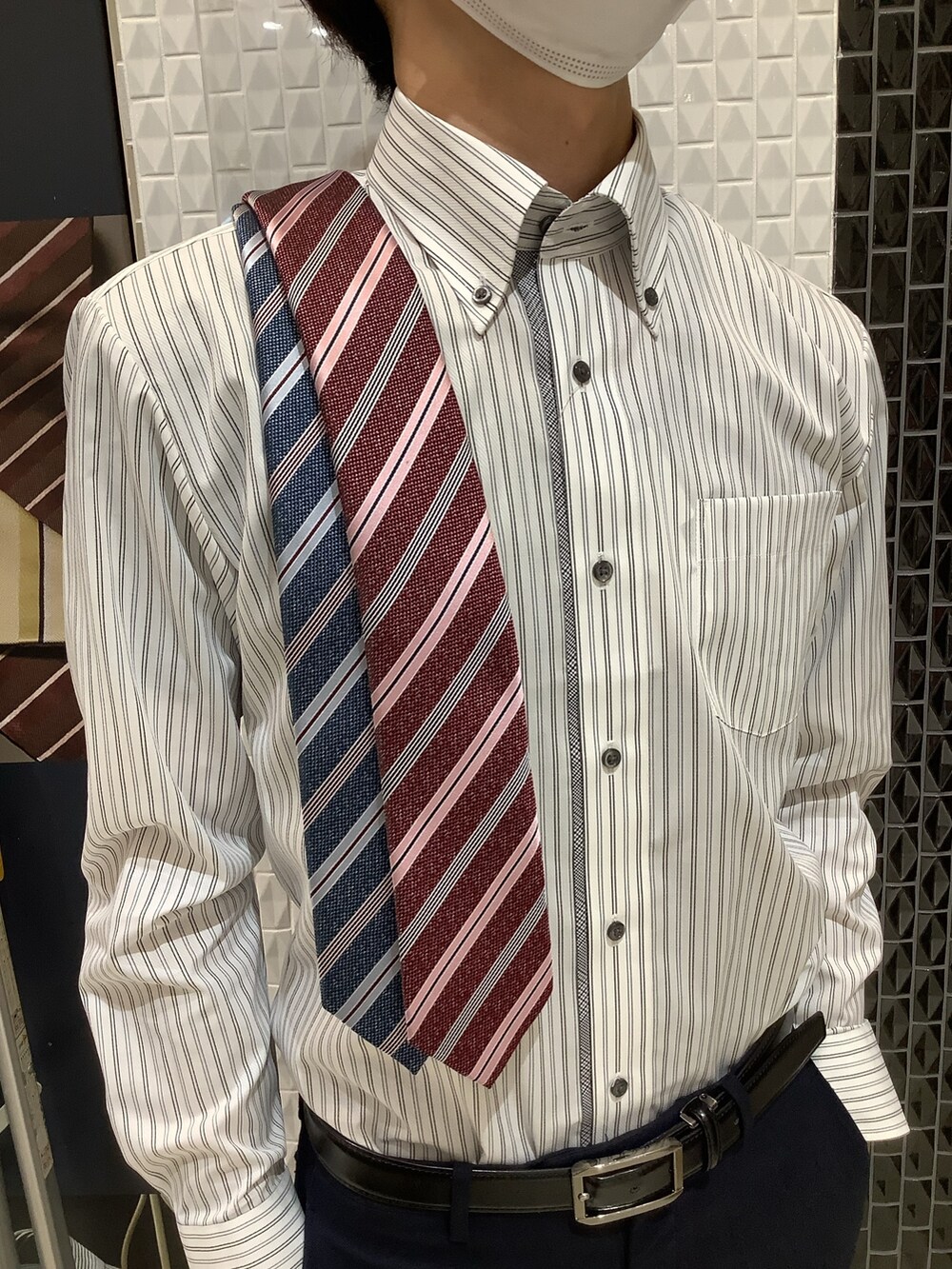 グレー系のビジネスシャツ、ブルー系のネクタイ、レッド系のネクタイを着用したメンズの春コーディネートの4枚目の写真