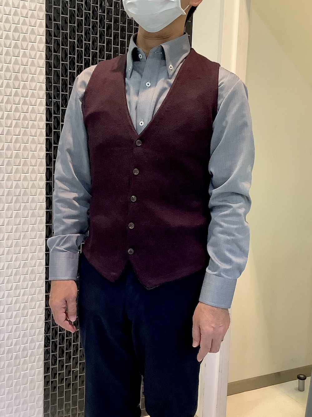 グレー系のビジネスシャツ、ブラウン系のベストを着用したメンズの秋コーディネートの2枚目の写真