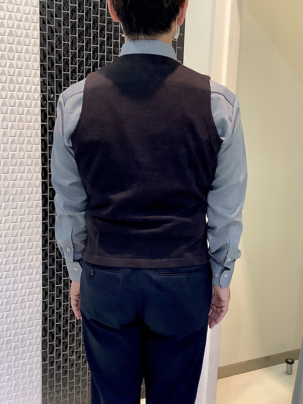 グレー系のビジネスシャツ、ブラウン系のベストを着用したメンズの秋コーディネートの3枚目の写真