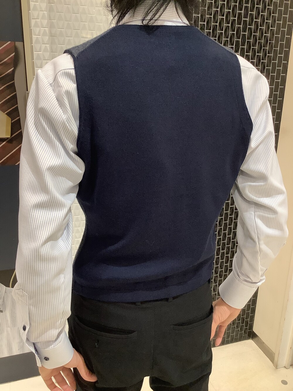 ブルー系のベスト、パープル系のネクタイ、ブルー系のビジネスシャツを着用したメンズの冬コーディネートの3枚目の写真