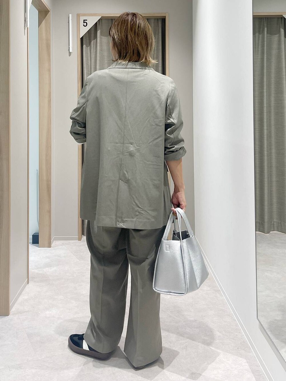 ブラック系のスニーカー、ベージュ系のテーラードジャケット、ベージュ系のスラックスを着用したレディースの秋コーディネートの5枚目の写真