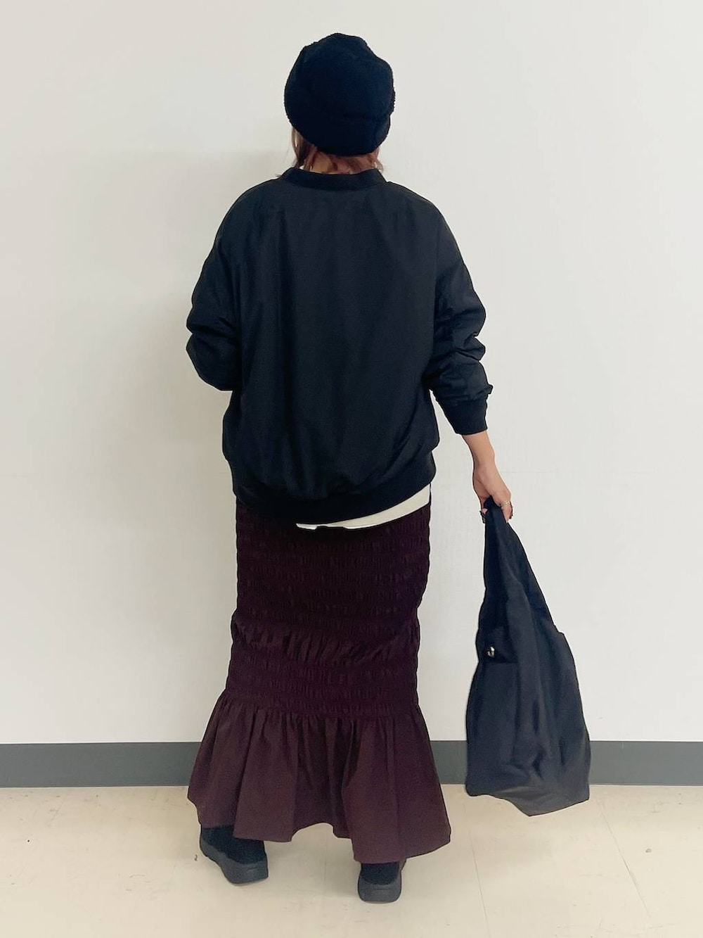 ブラック系のトートバッグ、ブラック系のブルゾン、ブラック系のブーツを着用したレディースの秋コーディネートの3枚目の写真